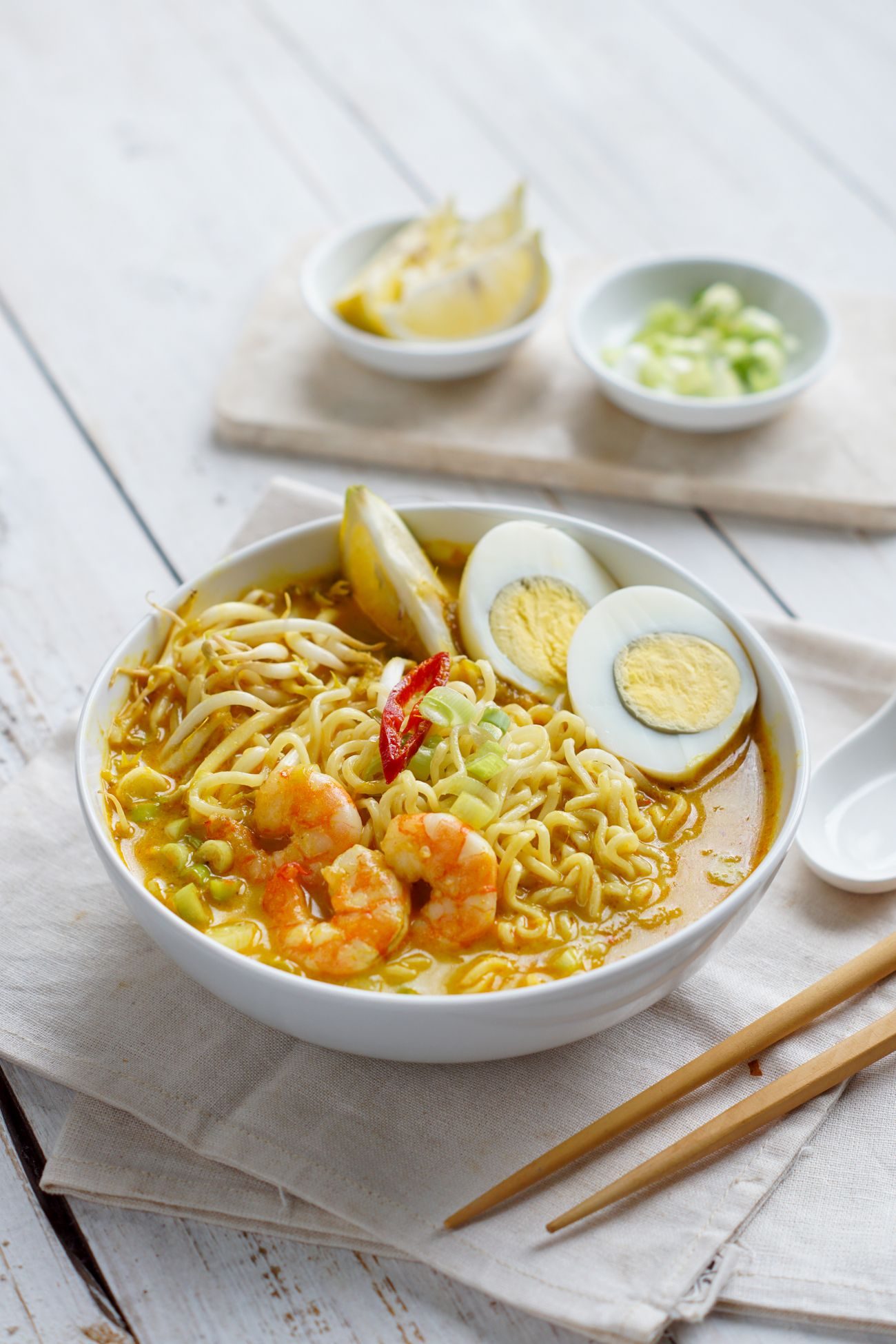 A bowl of laksa with prawns and egg